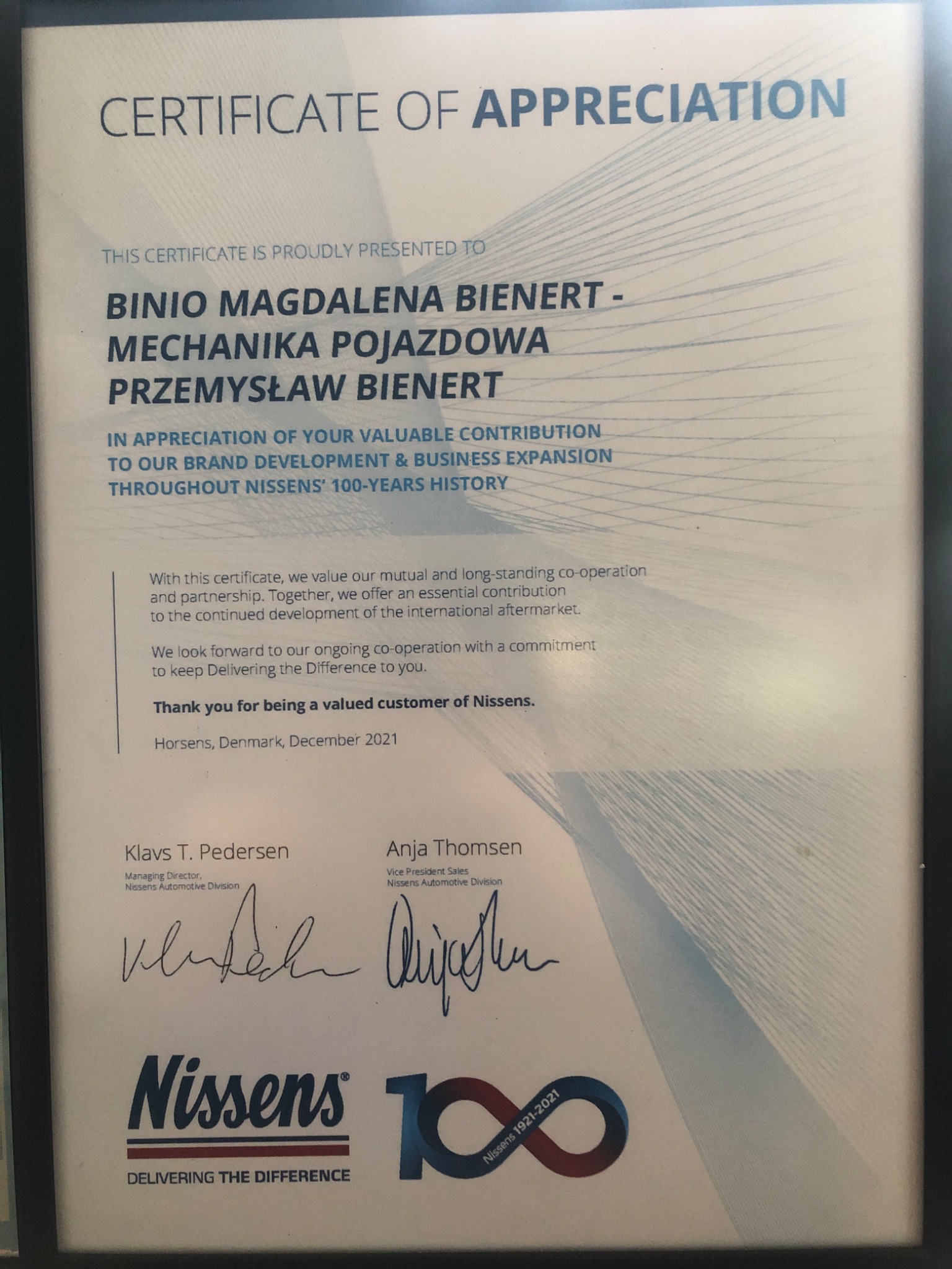 Oprawiony certyfikat uznania od firmy Nissens dla Binio Magdaleny Bienert, pojazdowej mechaniki, za wkład w rozwój marki, z podpisami Klavsa T. Pedersena i Anji Thomsen, wydany w Horsens, Dania,...