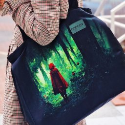 TairutoysSew - Torba shopper z nadrukiem Czerwonego Kapturka w lesie, noszona na ramieniu przez osobę w płaszczu w kratę, widoczne logo marki na małej naszywce.