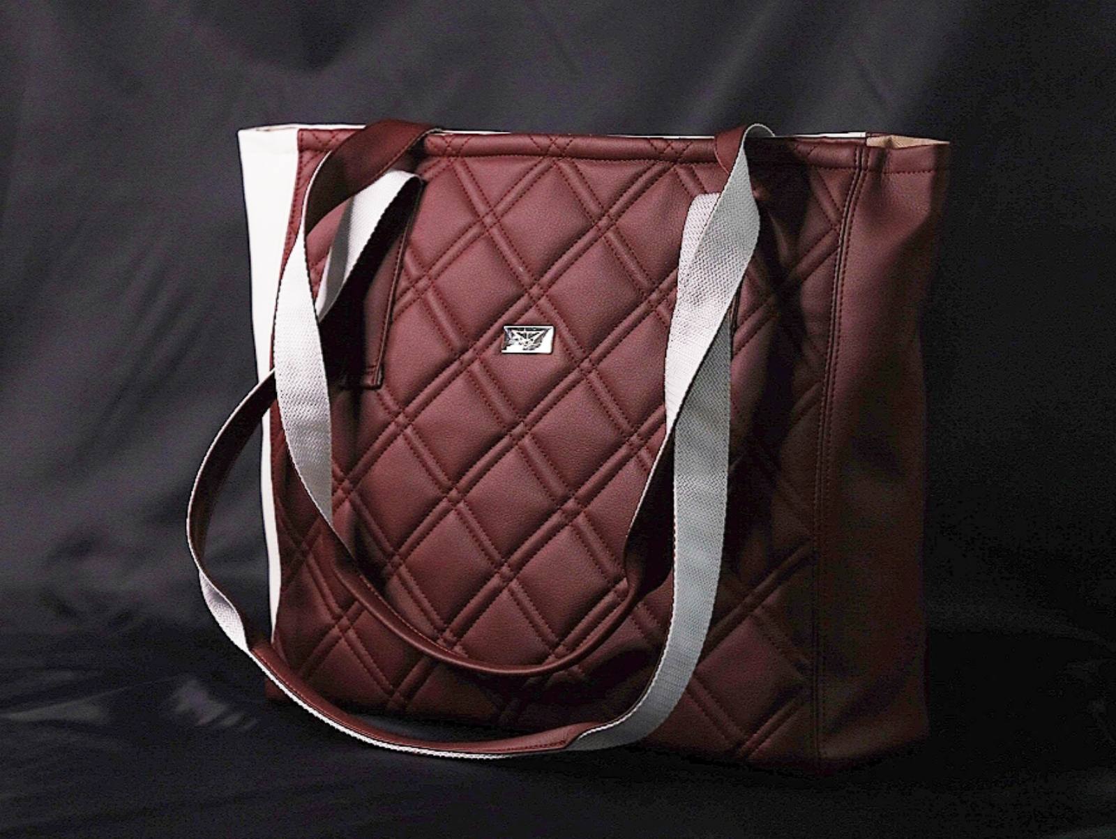 Burgundowa torebka shopper z pikowaniem w romby i srebrnym logo na czarnym tle.