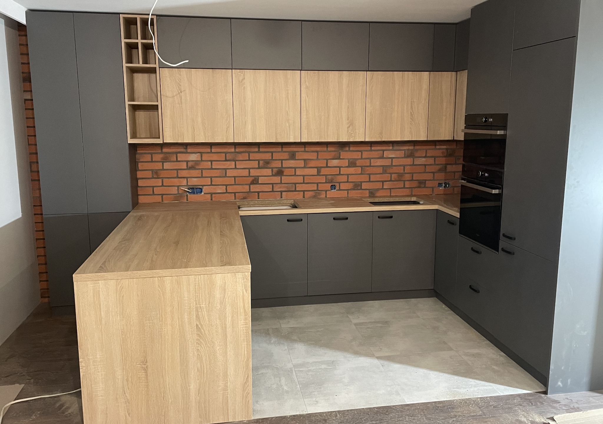 Kuchnia wykonana z płyty grafitowej U164 VL i Dąb Sonoma 3025 SN plus blat Dąb Sonoma