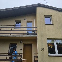 Power Sun Polska - Dostawa klimatyzacji do domu: kobieta w niebieskim kombinezonie wnosi karton z klimatyzatorem po schodach do budynku z numerem 40.