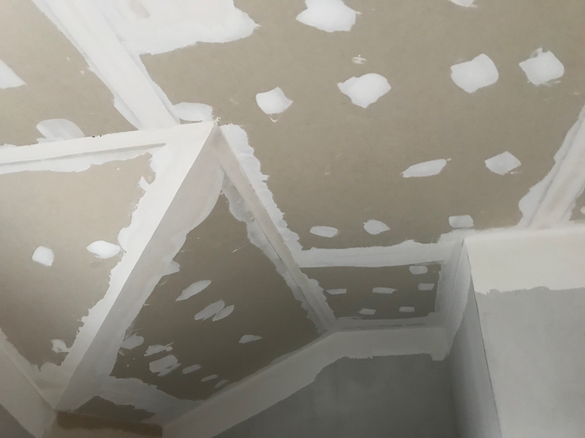 Sufit z zamontowanymi płytami, widoczne łączenia płyt i ślady szpachlowania przed malowaniem.