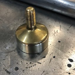 MARIUSZ GONDEK MAR-MONT - Mosiężny element tokarski z gwintem na metalowym stole warsztatowym z widocznymi śladami obróbki.