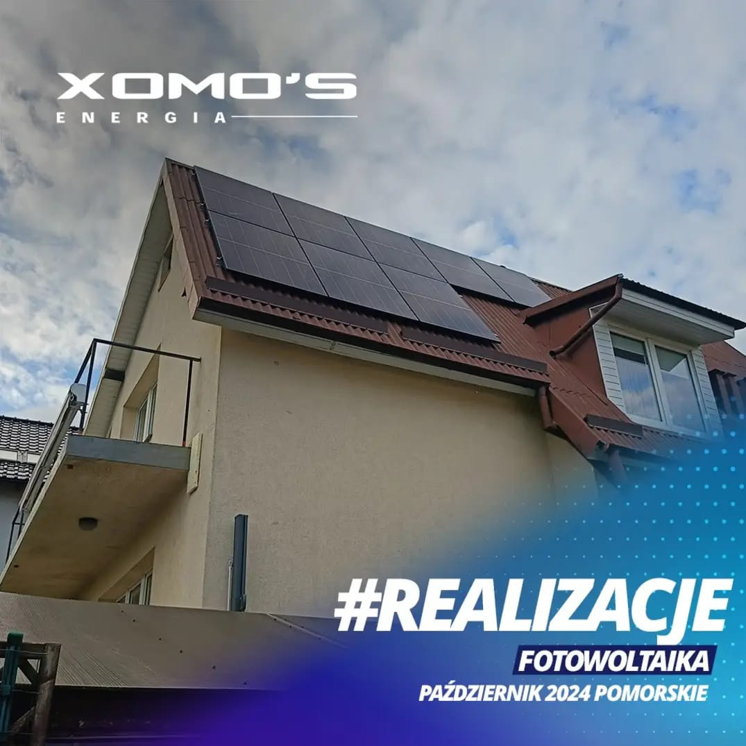 Instalacja paneli słonecznych na dachu domu w Raciborzu, widok z dołu, częściowo pochmurne niebo w tle.