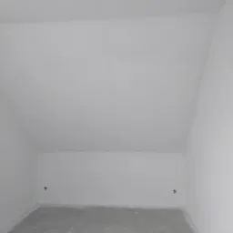 Poddasze po szpachlowaniu i gruntowaniu ścian, widoczne gniazdka elektryczne, surowy beton na podłodze, przygotowane do dalszych prac wykończeniowych.