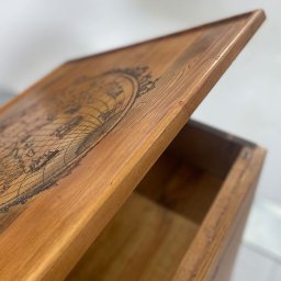 PAPAJ Sp. z o.o. - Otwarta, drewniana skrzynia z wygrawerowaną mapą świata na wieku, ukazująca wnętrze i detale obrzeży.