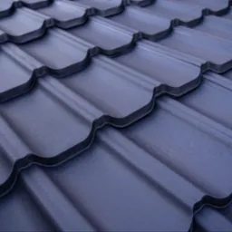 Ciemnoszare dachówki metalowe, ułożone pod kątem, z widoczną fakturą i detalami łączeń.