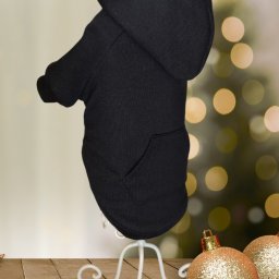 AW Designer Aleksandra Wisińska - Czarna bluza z kapturem dla psa, prezentowana na białym stojaku, z świątecznym tłem i złotymi bombkami.