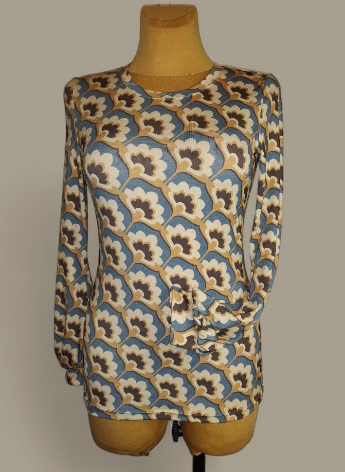 Damska bluzka z długim rękawem, w retro wzór kwiatowy w odcieniach błękitu, beżu i brązu, drapowana po jednej stronie na manekinie.
