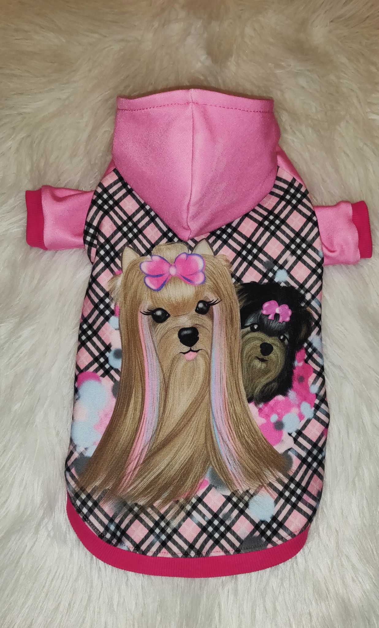 Różowa bluza z kapturem dla psa z nadrukiem dwóch yorków z kokardkami na białym, puszystym tle.