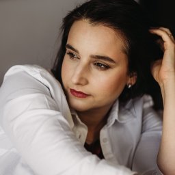 Asia Wiśniewska Fotografie, Joanna Wiśniewska - Portret kobiety w białej koszuli, z ciemnymi włosami, delikatnym makijażem i pierścionkiem na palcu, spoglądającej w lewo