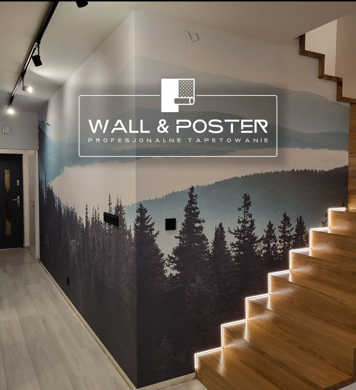 Ściana z fototapetą przedstawiającą górski las, sąsiadująca z drewnianymi schodami z oświetleniem LED, widoczny fragment korytarza z czarnymi drzwiami.