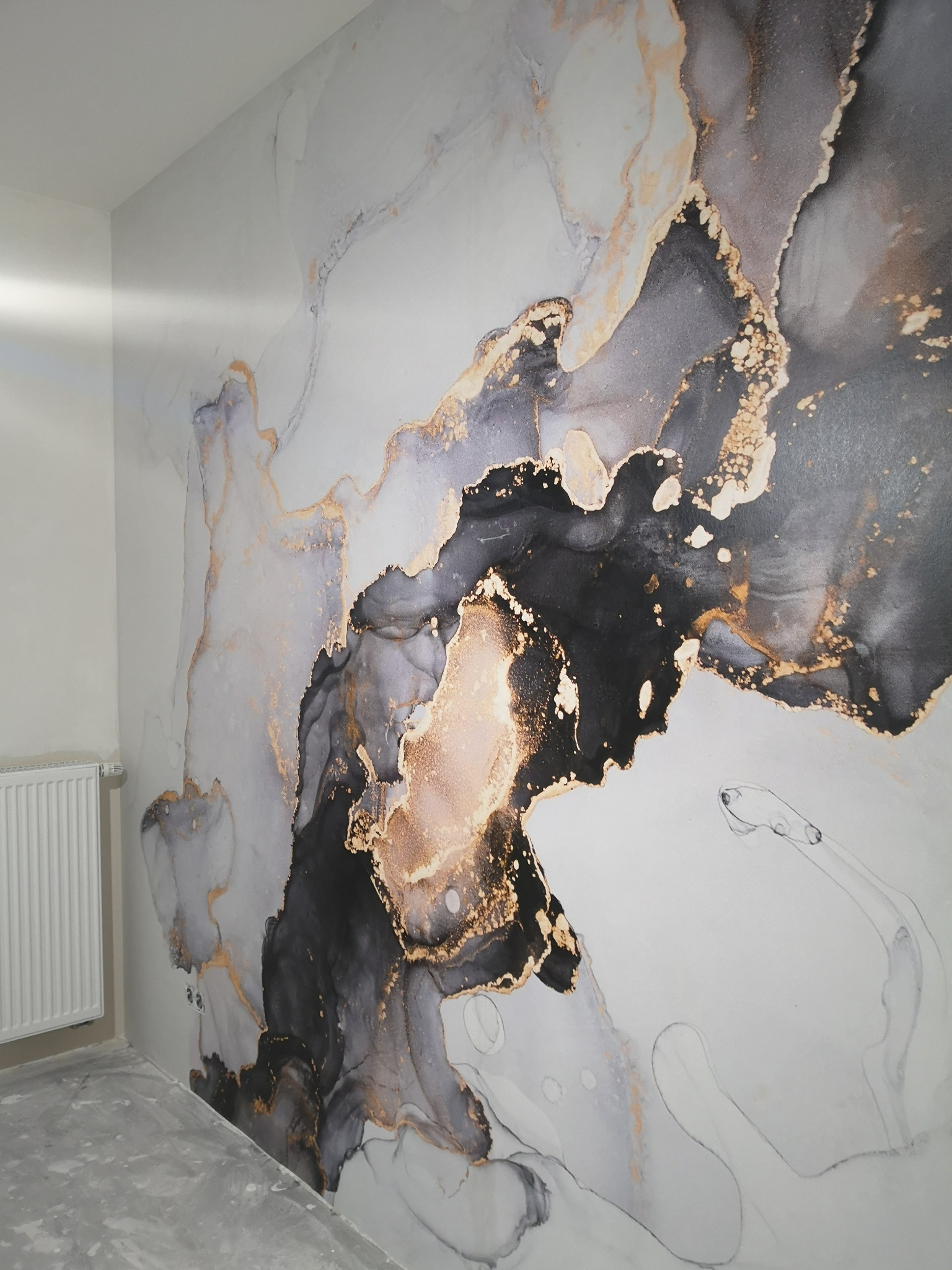 Ściana z fototapetą imitującą marmur w odcieniach szarości, czerni i złota, widoczny fragment grzejnika.