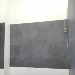 ,,BRODA-BUD” PRZEMYSŁAW MASTERNAK - Szare płytki na ścianie w łazience, białe ściany powyżej i poniżej, widoczne przewody elektryczne.