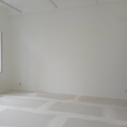 ,,BRODA-BUD” PRZEMYSŁAW MASTERNAK - Wnętrze biura w trakcie remontu, widoczne gładkie, białe ściany, surowa podłoga z widocznymi śladami po gładzi, oraz wiszące lampy sufitowe.