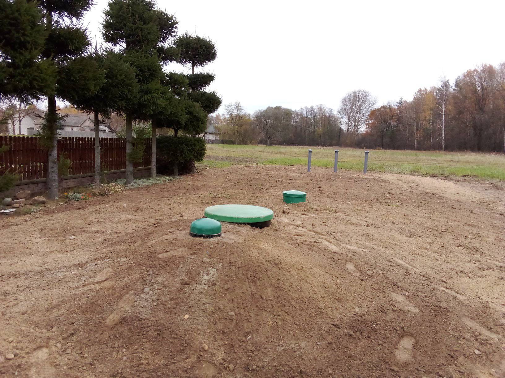 Instalacja ekologicznej oczyszczalni: widoczne trzy zielone pokrywy zbiorników oraz cztery pionowe rury odpowietrzające na wykopanym terenie.