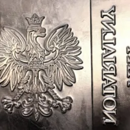 Metalowa matryca z wytłoczonym orłem w koronie i odwróconym napisem.