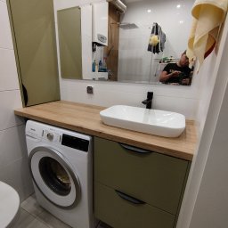 Vibe Wood - Nowoczesna łazienka z zabudową na wymiar w odcieniach bieli i oliwki, z pralką wkomponowaną pod blatem umywalki i dużym lustrem odbijającym fragment kabiny prysznicowej.