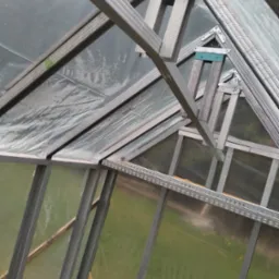 Wnętrze szkieletu konstrukcji poddasza z metalowych profili, widoczne elementy mocujące i folia izolacyjna.