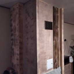 PPUH Pierlak szymon - Ściana kominkowa w trakcie szpachlowania w Sopotni Wielkiej, widoczne ślady po szpachli i kratka wentylacyjna.