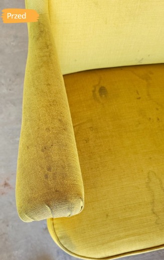 Żółty fotel tapicerowany z widocznymi plamami i zabrudzeniami na oparciu i siedzisku. Zdjęcie 'przed' czyszczeniem, ukazujące stopień zanieczyszczenia.