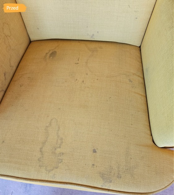 Żółty fotel z plamami, widok z góry, stan 'przed' zabiegiem czyszczenia tapicerki w Dąbrowie Górniczej. Intensywne zabrudzenia na siedzisku i oparciu.