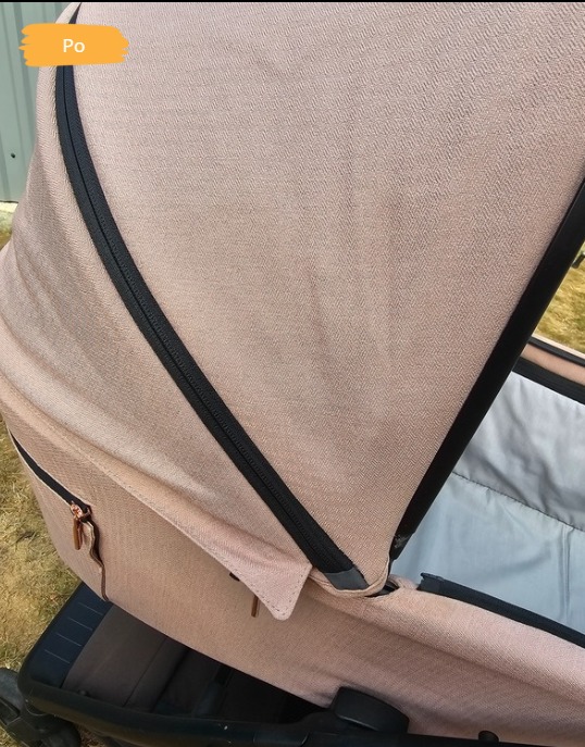 Wózek dziecięcy z jasnoróżową tapicerką, widoczny po czyszczeniu. Ujęcie z bliska, prezentujące detale materiału i efekt 'po'.