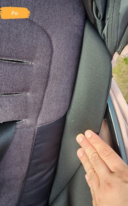 Wyprana tapicerka wózka dziecięcego, widoczna po czyszczeniu, z bliska. Dłoń wskazuje na czystą powierzchnię.