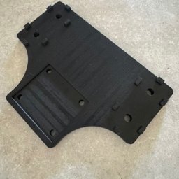 LAB17 Łukasz Andrejczuk - Czarny, nieregularny kształt z tworzywa z otworami i wypustkami, wykonany techniką druku 3D. Widoczne warstwy materiału i struktura powierzchni.