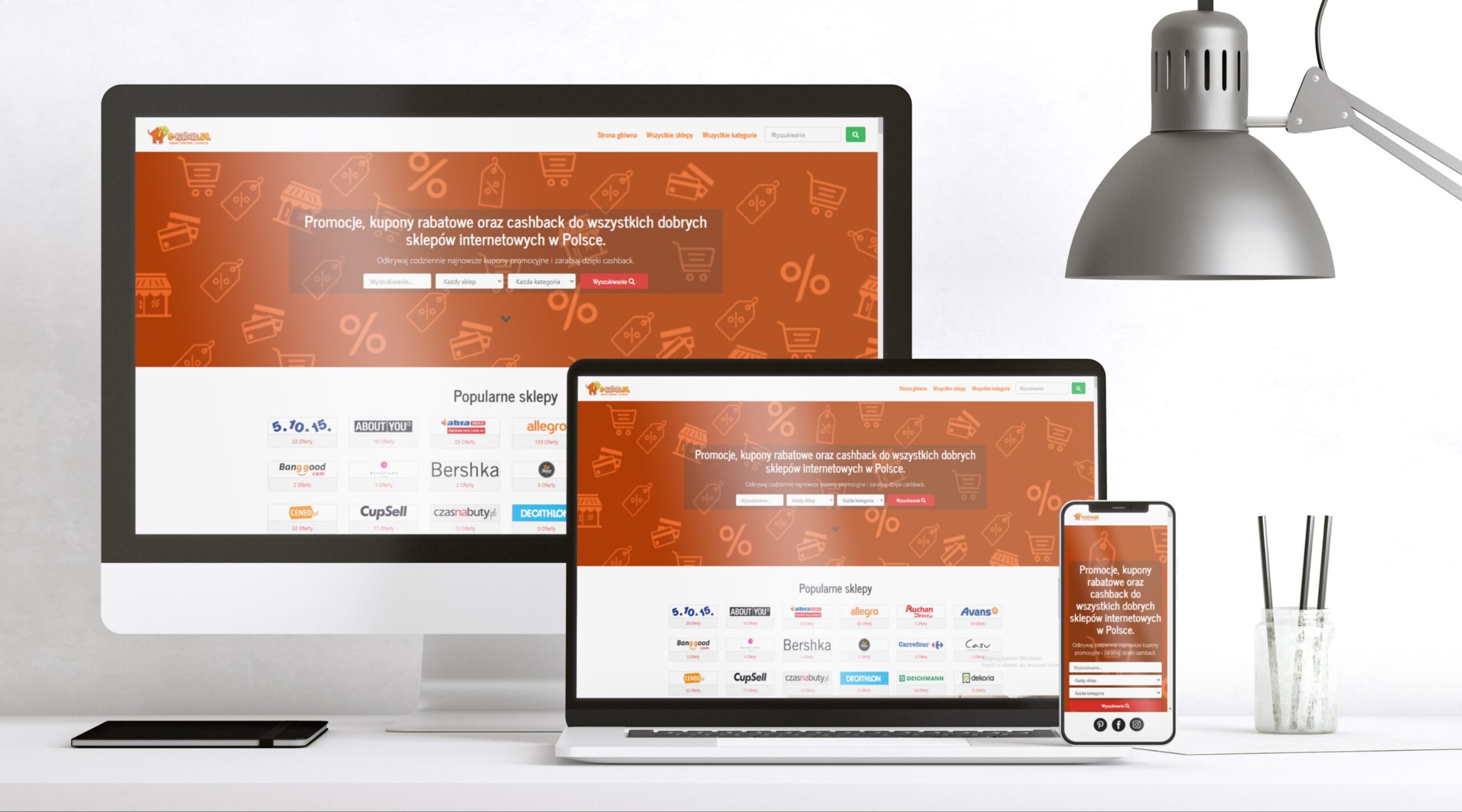 Ekran komputera stacjonarnego, laptopa i smartfona wyświetlające identyczną stronę internetową z promocjami i kuponami rabatowymi dla sklepów online, oświetlone lampą biurkową