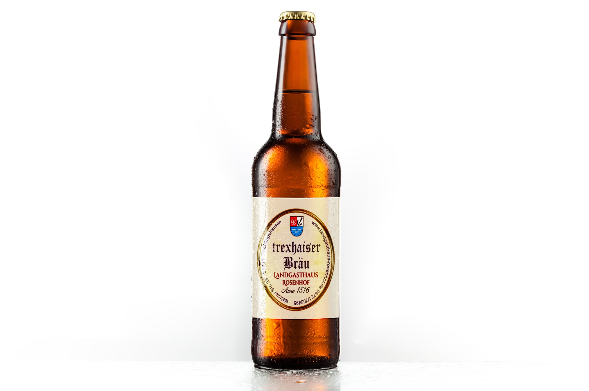 Butelka brązowego piwa Trexhauser Bräu Landgasthof Rosenhof Anno 1516 z kroplami wody na etykiecie, na białym tle.