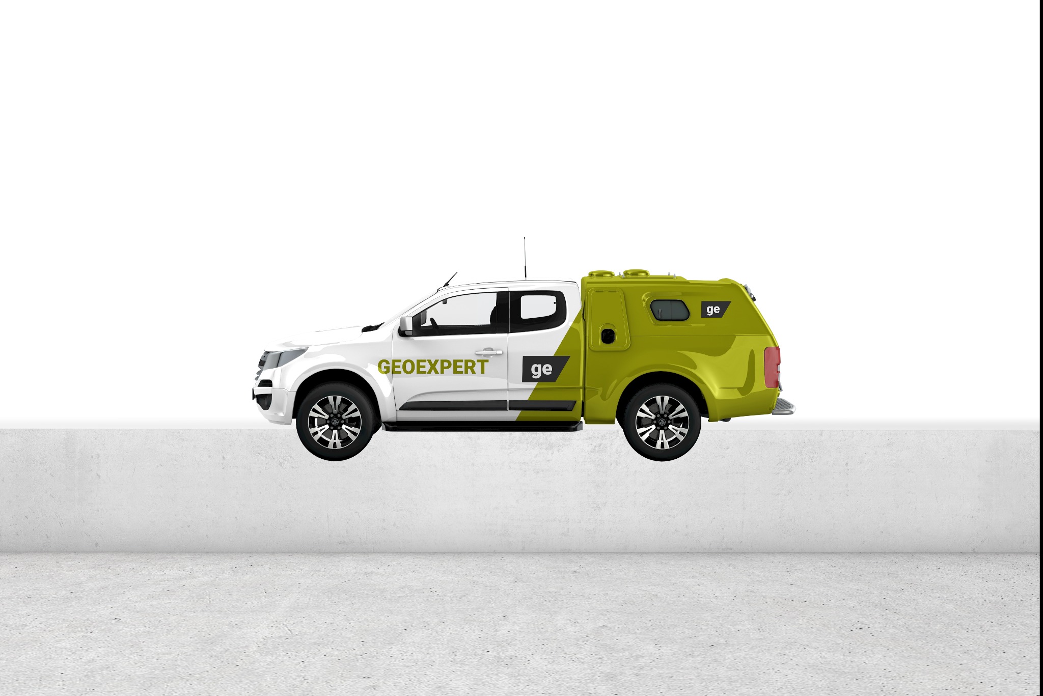 Biało-zielony pick-up Geoexpert z zabudową, prezentowany z boku na tle betonowej ściany i podłoża.