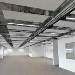 Widok na sufit podwieszany z płyt kartonowo-gipsowych w przestronnym biurze w Bytomiu, z widocznymi instalacjami i oświetleniem.