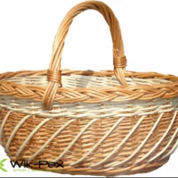 Ręcznie wyplatany kosz z wikliny w odcieniach beżu i kremu, z widocznym logo producenta w lewym dolnym rogu.