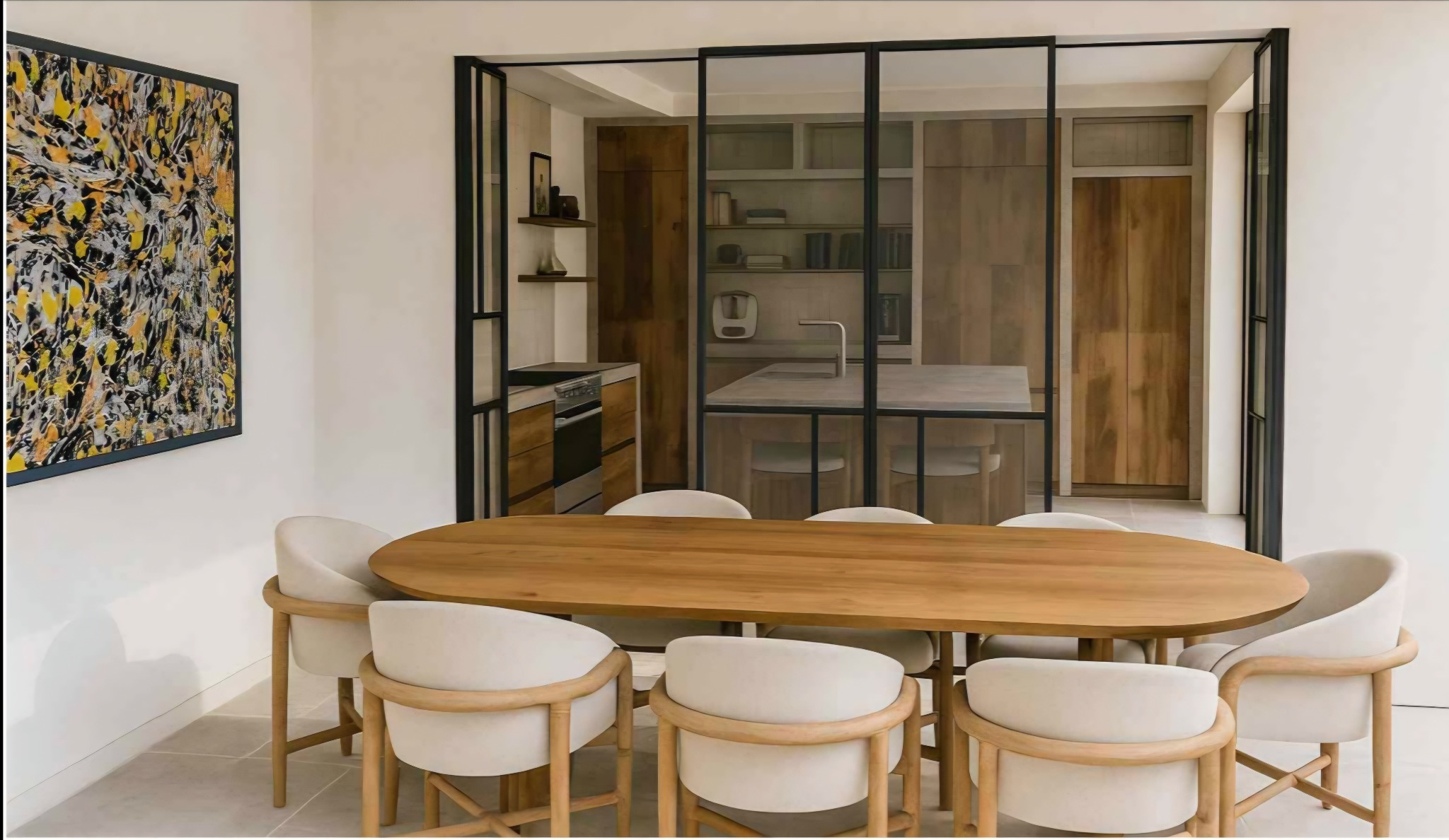 Nowoczesna jadalnia z drewnianym stołem i krzesłami w odcieniach beżu, oddzielona szklaną ścianą od kuchni z drewnianą zabudową. Na ścianie abstrakcyjny obraz.