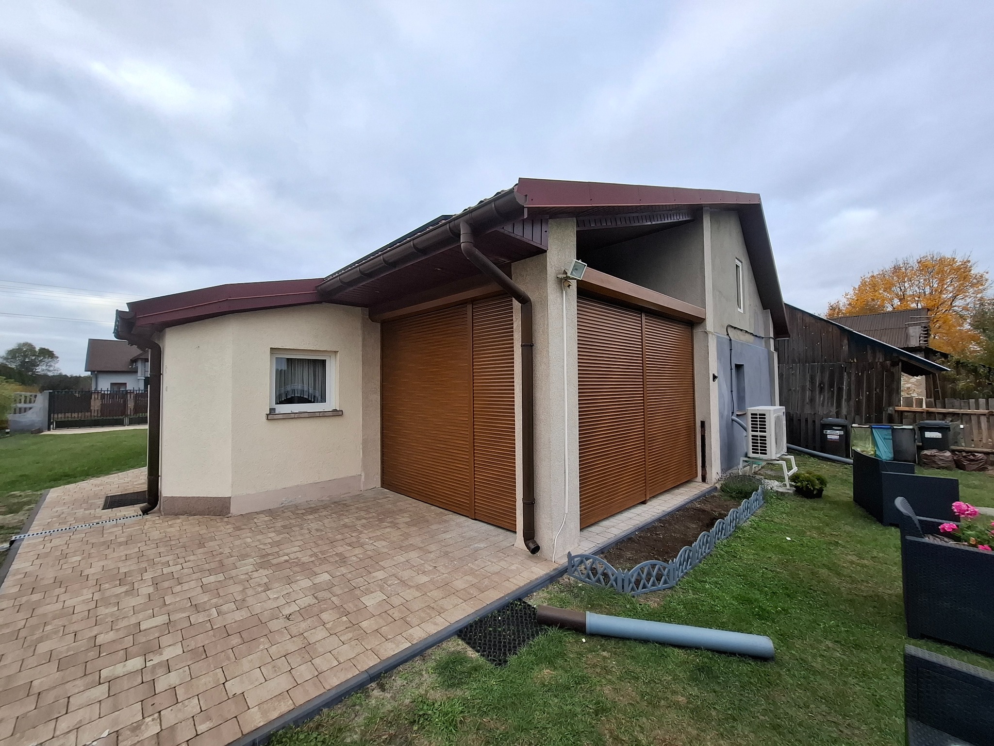 Zewnętrzne rolety w kolorze brązowym zamontowane na budynku z jasną elewacją, widoczne z poziomu posesji. Uwagę zwraca estetyczne wykończenie i dopasowanie kolorystyczne.