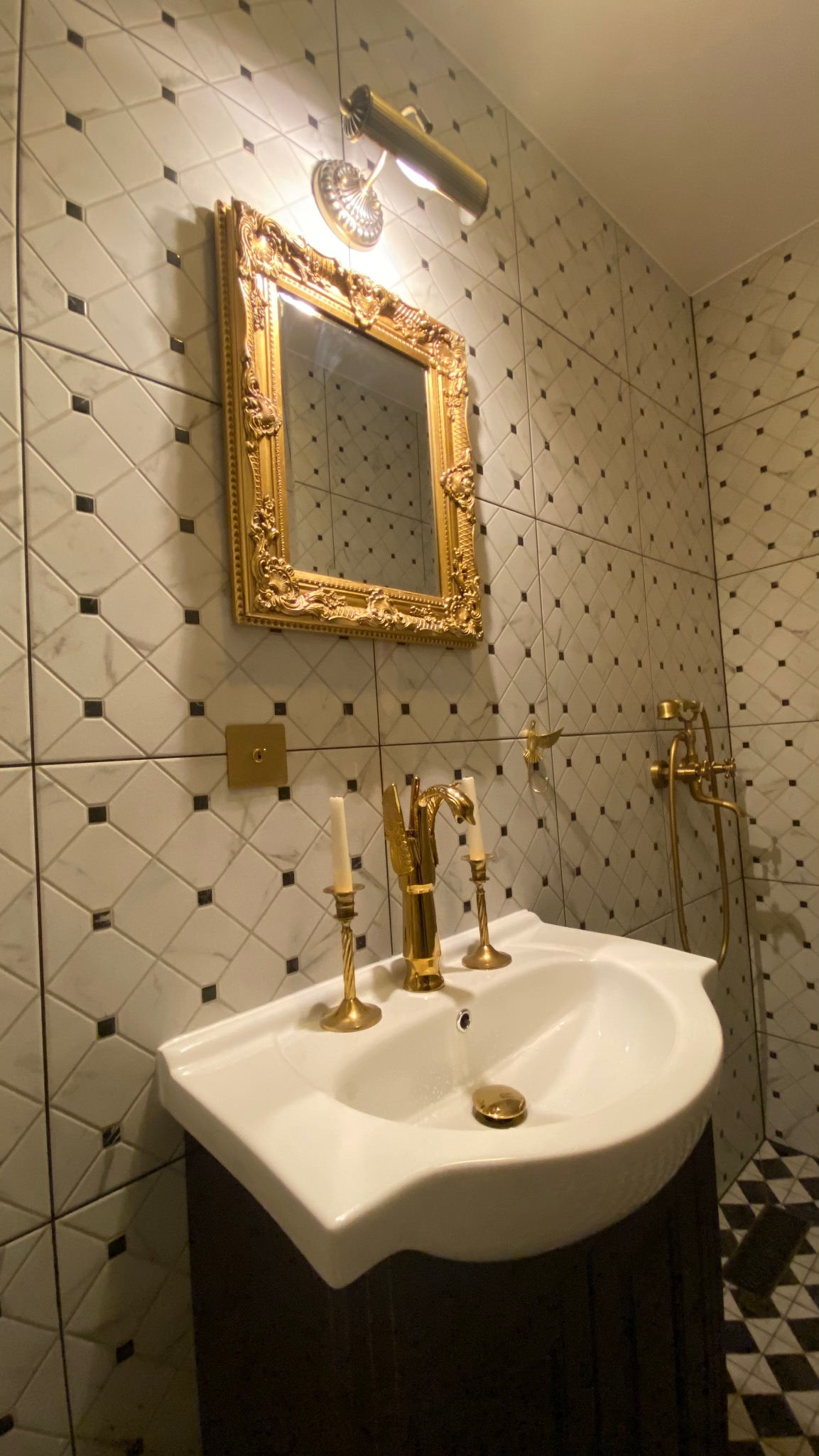 Elegancka umywalka z armaturą w kolorze złota, w łazience wykończonej w biało-czarną kratę. Detale wykończenia w stylu retro, Warszawa.