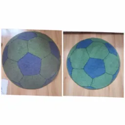 Okrągły dywan dziecięcy w kształcie piłki nożnej, z zielonymi i niebieskimi panelami, leżący na panelach podłogowych; widoczne dwie wersje dywanu: przed i po czyszczeniu.