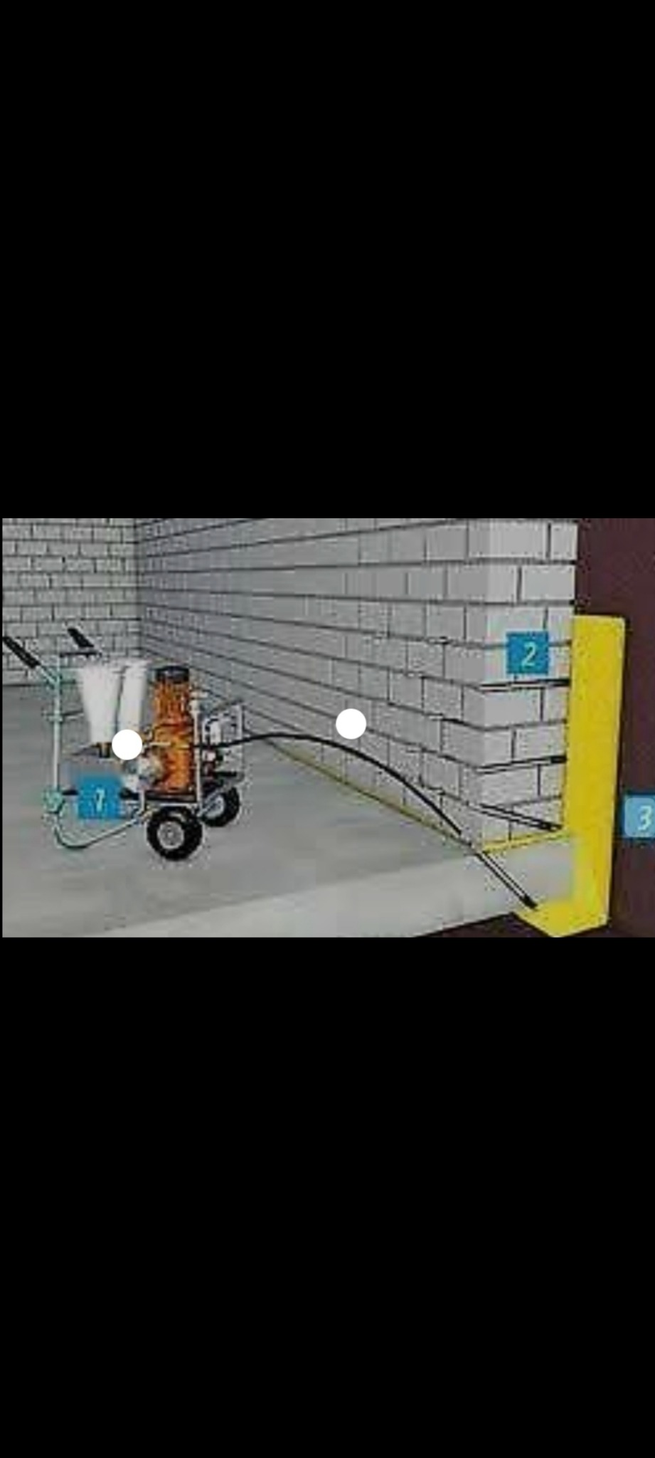 Aplikacja izolacji natryskowej na fundament za pomocą specjalistycznego agregatu malarskiego, widoczna ściana z cegły i żółta izolacja pionowa.