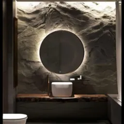 Nowoczesna łazienka z okrągłym lustrem podświetlanym LED, umywalką nablatową na blacie z surowego drewna i ścianą z dekoracyjną fakturą przypominającą piaskowiec.