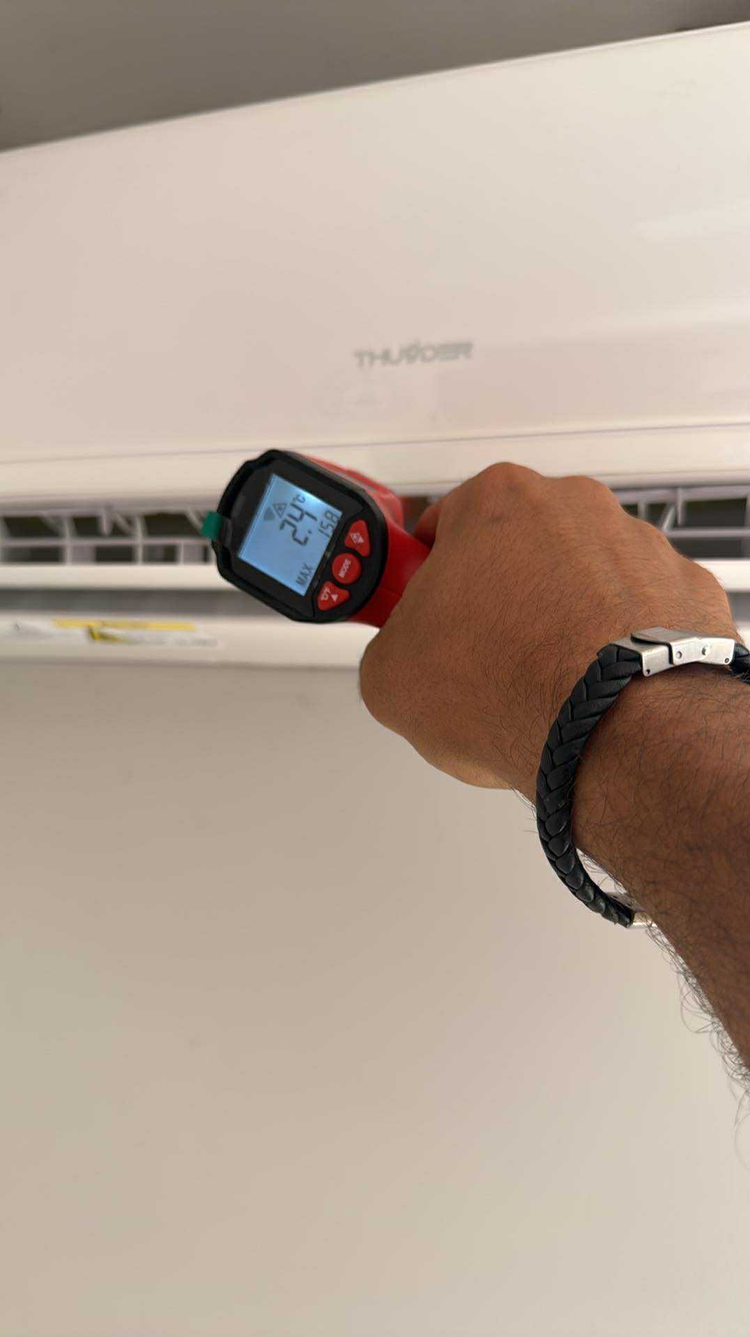 Pomiar temperatury klimatyzatora ściennego termometrem laserowym. Na ekranie termometru widoczna temperatura 24,2 stopnie Celsjusza.