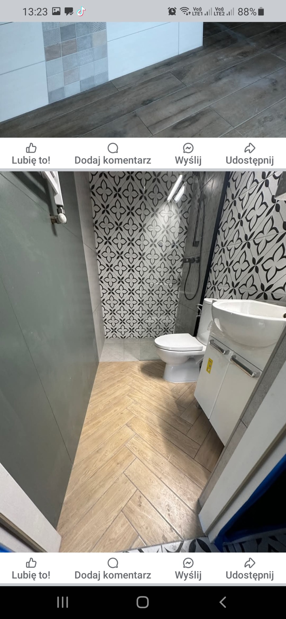 Wnętrze wykończonej łazienki z beżową podłogą ułożoną w jodełkę, białą ceramiką sanitarną i ścianą w czarno-białe wzory.