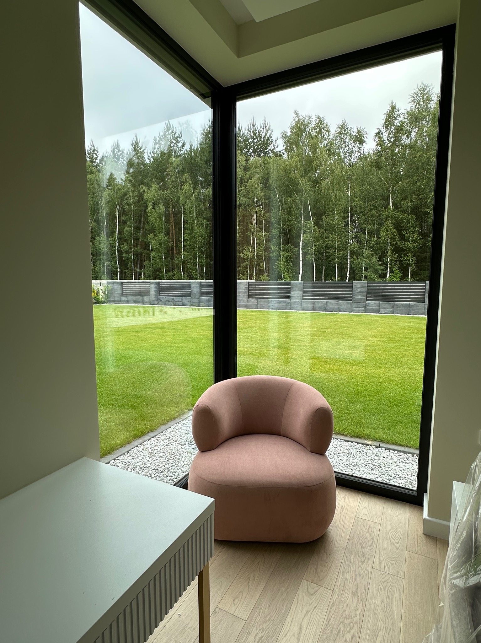 Jasny pokój z dużym oknem na ogród. Wnętrze dopełnia różowy fotel i biurko z frezowanymi frontami. Podłoga wyłożona panelami.