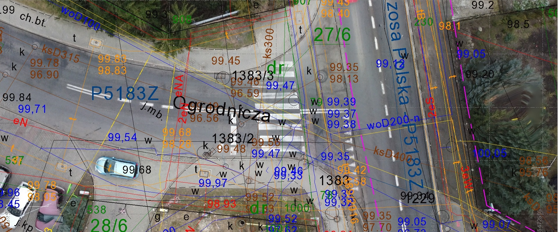 Skan mapy geodezyjnej z naniesionymi numerami działek, granicami, elementami infrastruktury drogowej i zielenią, widziany z lotu ptaka.