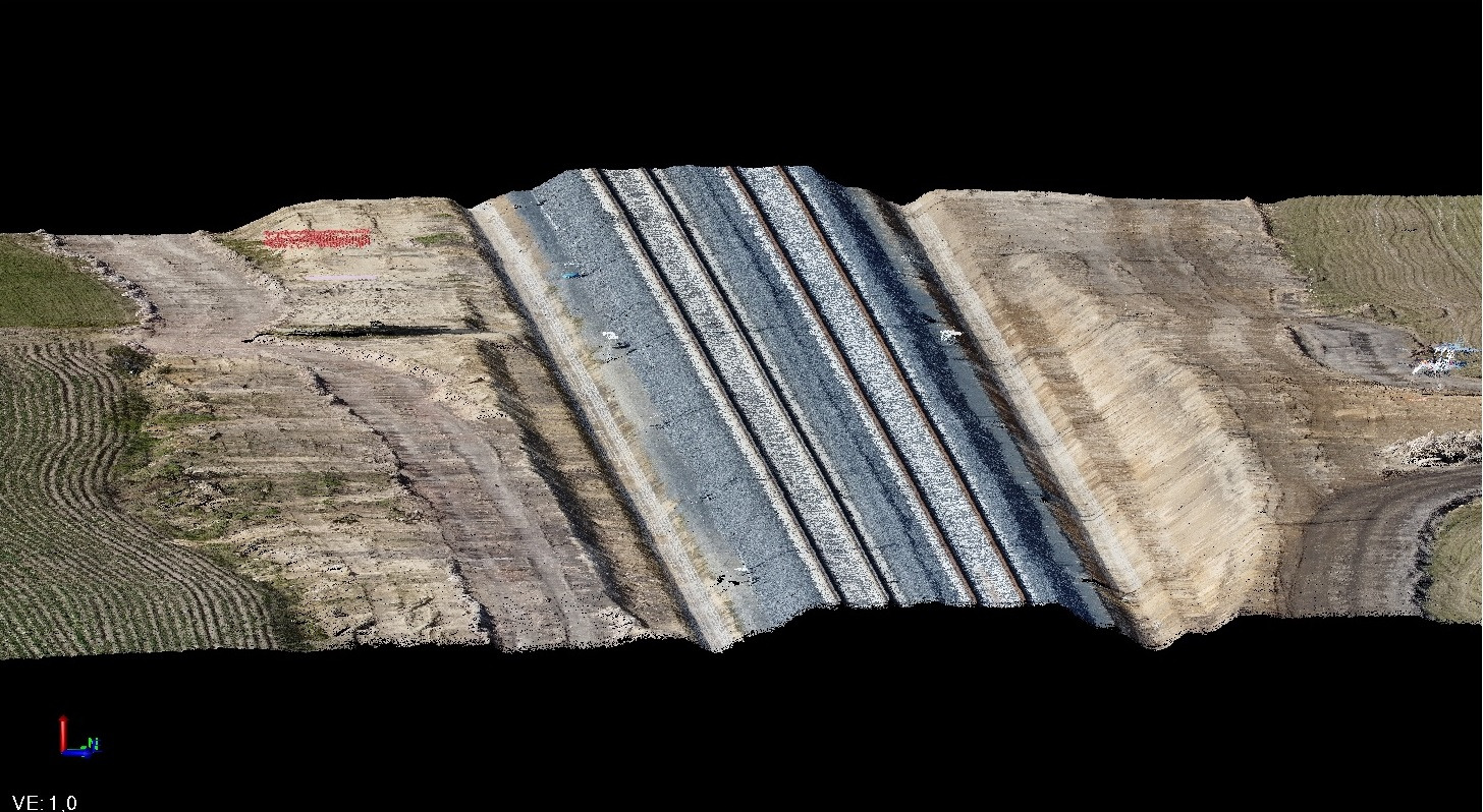 Skan 3D terenu z widoczną linią kolejową, otoczenie ziemne i roślinne, wizualizacja inżynieryjna.