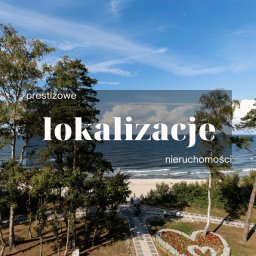 Madro Real Estate Szczecin - Kreatywna sprzedaż nieruchomości - Pas nadmorski - Widok na morze z parku miejskiego z alejkami, klombem w kształcie serca i drzewami; w tle plaża i błękitne niebo z chmurami.