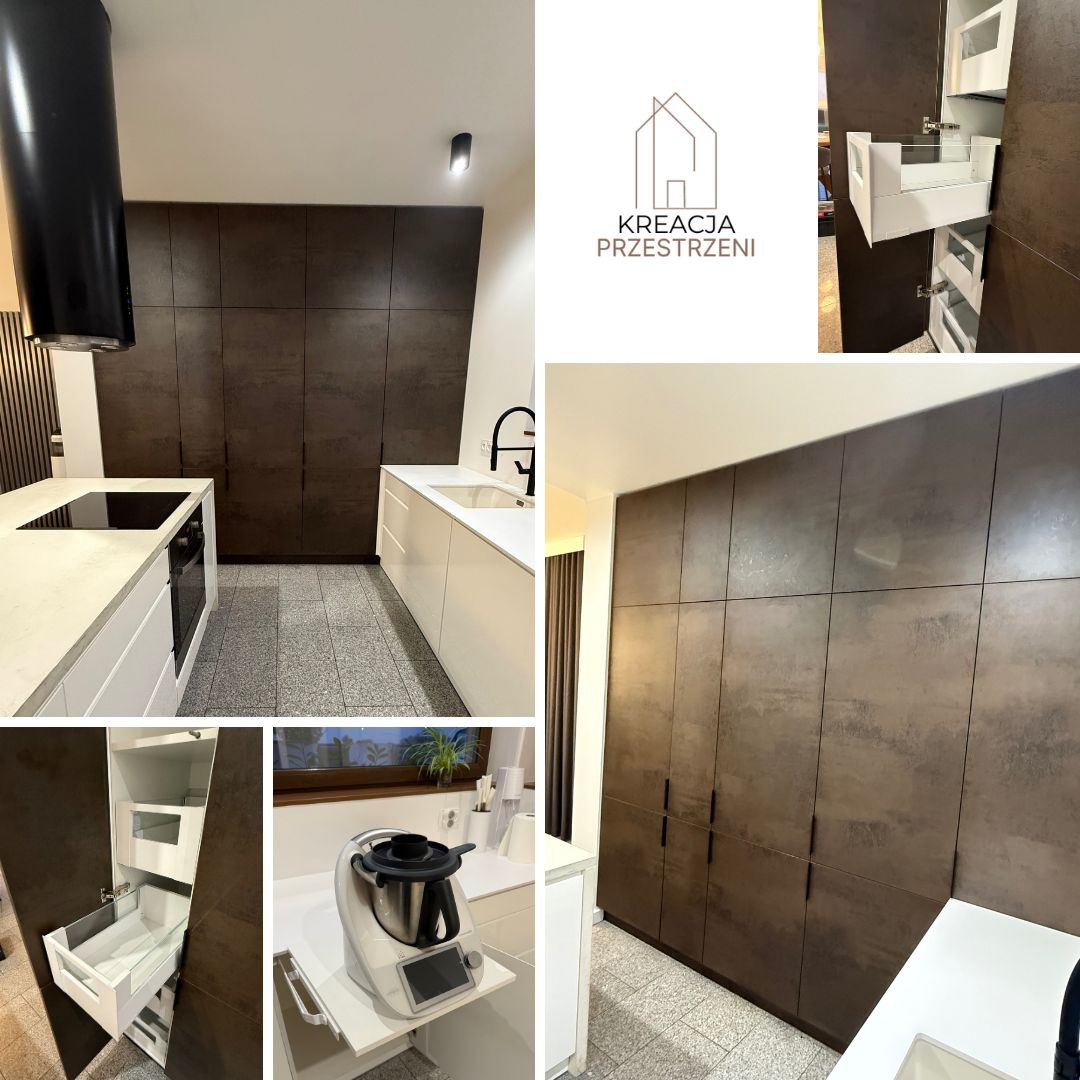 Nowoczesna kuchnia z brązowymi, teksturowanymi frontami szafek na całej ścianie, białymi blatami i wysuwką dla Thermomixa, czarny okap nad płytą indukcyjną, widoczne akcesoria Blum.