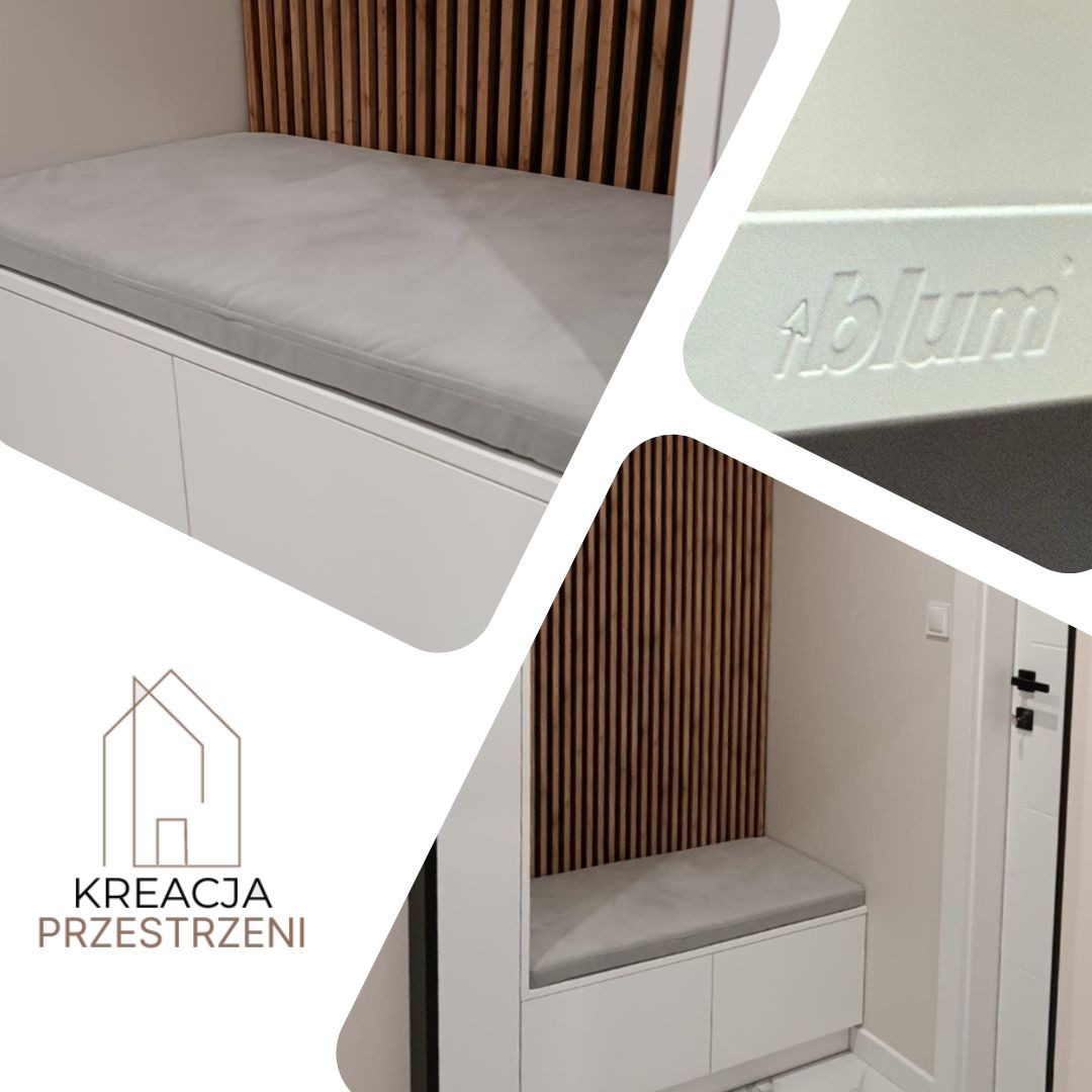 Biała szafa wnękowa z tapicerowanym siedziskiem i lamelami z naturalnego drewna, widoczne logo Blum, ujęcie z perspektywy wejścia do pomieszczenia.