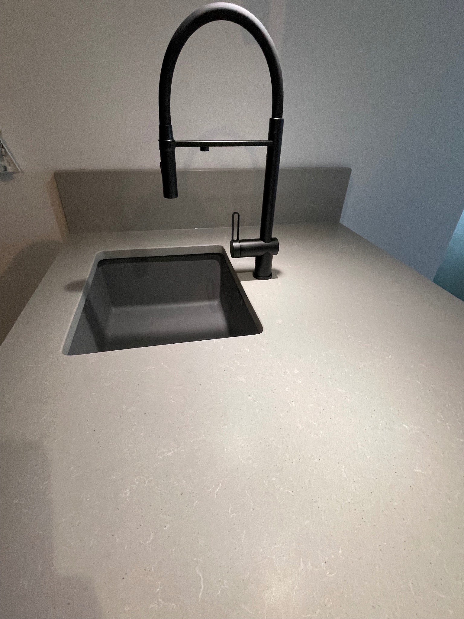 Jasny blat kamienny z czarnym zlewem i baterią we Włocławku. Minimalistyczny design, gładka powierzchnia, nowoczesne wykończenie.