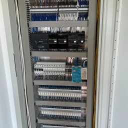 Roztech - Otwarta szafa sterownicza z rozbudowanym okablowaniem, modułami sterującymi i listwami zaciskowymi, widoczne przewody w różnych kolorach oraz elementy montażowe.